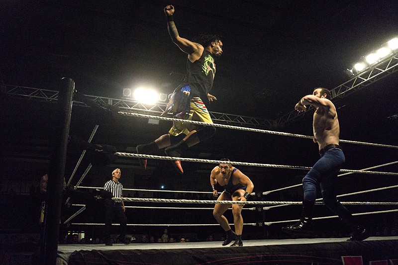 Jimmy Uso, left, of The Usos goes airborne toward Aiden English, right, of the The Vaudevillains during the opening tag-team match Monday at WWE Live at the Four States Fairgrounds. 