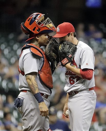 St. Louis Cardinals catcher Yadier Molina talks to relief pitcher Matt Bowman during the 10th inning of a baseball game against the Milwaukee Brewers Tuesday, Aug. 30, 2016, in Milwaukee. 