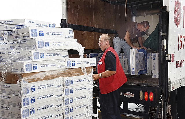 Tim Young helps Tom Brant load the box fans onto the truck Wednesday for delivery to The Salvation Army. Westlake Ace Hardware collected enough donations to purchase 78 20-inch box fans to be given away to clients in need. Young works for the hardware store and used a hand truck to haul them.