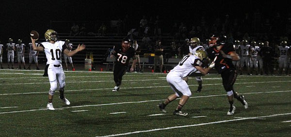 Eldon senior quarterback Austin Kempker prepares to fire a pass downfield as Owensville defender Cameron McQueen closes in during last Friday night's game in Owensville.