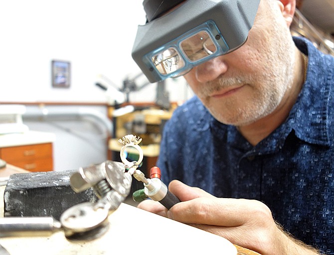 Brian Fuller, owner and jeweler at Fuller and Associates Jewelry in Fulton, repairs a ring Thursday using fire.