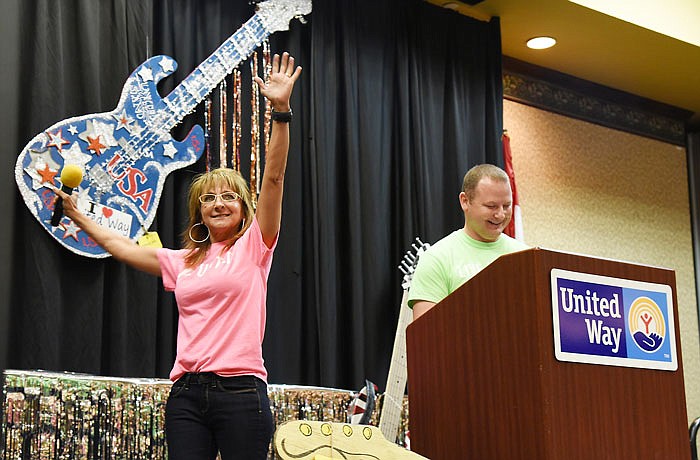 Jayne Dunkman raises her arms as it is announced the pacesetters collected total of $852,553, which is 48.3 percent of this year's United Way goal. Dunkman and co-chair Matt Tollerton, right, were the emcees of Thursday's United Way Community Campaign Kickoff at the Capitol Plaza Hotel.
