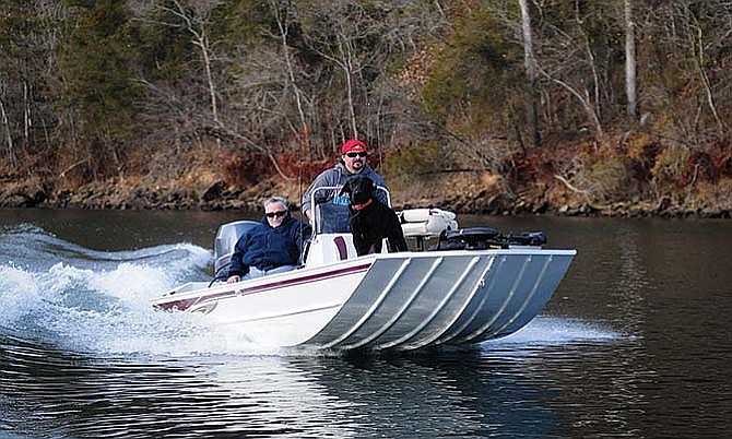 Spencer Turner, sitting behind Brandon Butler, enjoys his last ride on Lake Taneycomo where he spent much time working as a trout biologist.