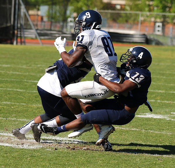 Lincoln receiver Deonte Latimer gets tackled by two defenders during the Spring Game at Dwight T. Reed Stadium. The receiving corps is expected to be a strength for the Blue Tigers this season. 
