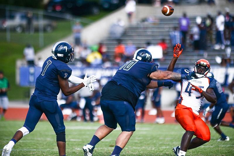 Lincoln University quarterback Dennis Vinson, #7, launches the ball over the head of offensive lineman Carlos Lozano, #70, as he keeps a Langston defender at bay during their game on Saturday, Sept. 3, 2016 at Dwight T. Reed Stadium.  