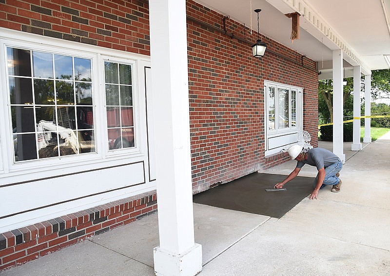 Tom Startzman, of Septagon Construction, smooths the concrete at what will be the new entryway at Jefferson City Manor. The nursing home is undergoing extensive remodeling and updating.