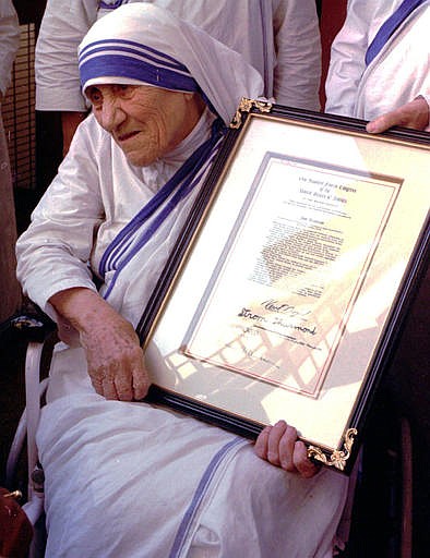 In this Saturday, Nov. 16, 1996 file photo, Mother Teresa holds the resolutions of honorary American citizenship after they were presented to her by American Ambassador to India Frank G. Wisner at the Missionaries of Charity in KolKata, formerly known as Calcutta, India. With Sunday, Sept. 4, 2016 making the canonization of Mother Teresa, Pope Francis honored the tiny nun who cared for the "poorest of the poor" as the epitome of his call for mercy. Here are some significant dates in the life of the Catholic Church's newest saint. 