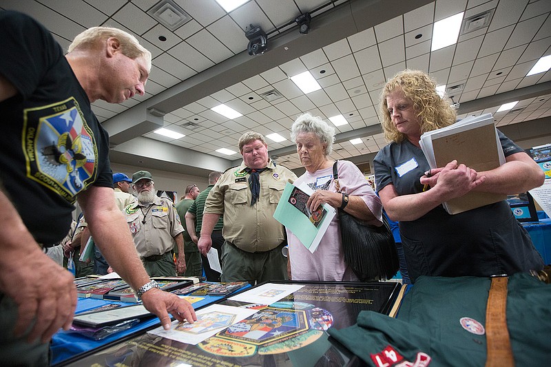 Charles Norton discusses the new design for the Caddo Area Council's Scout-O-Rama patch Tuesday, Sept. 6, 2016 with Julie Lowrey, Ruby Vallee of De Queen, Ark.- based Cub Scout Pack 54 and Will Gilbert with Boy Scout Troop 1149 of Texarkana, Texas, during the 2016-17 program preview for Cub and Boy Scouts of the Caddo Area Council. The event, held at Williams Memorial United Methodist Church, gives Scout leaders an opportunity learn of upcoming Scouting events. More than 200 volunteers were expected to attend.