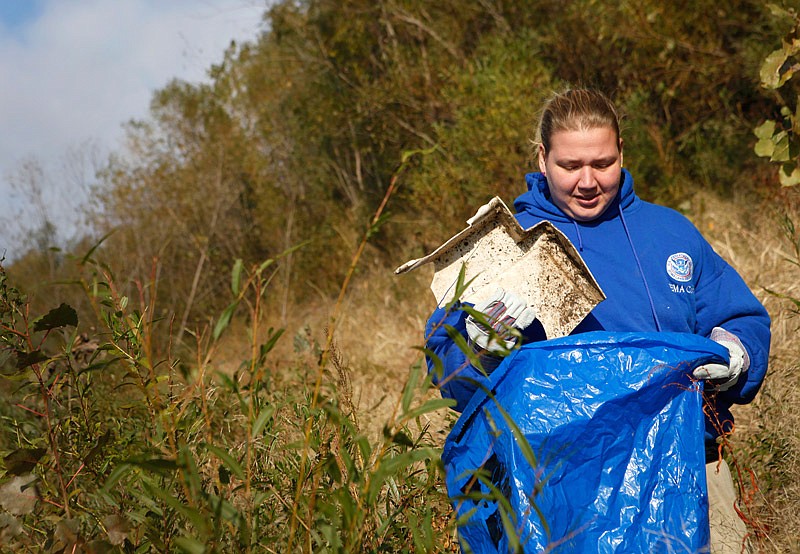 In this Oct. 19, 2013 News Tribune file photo, Rachel Conger, participating in the Missouri River Relief clean-up, places a piece of plastic into her trash bag near Hartsburg, Mo.  