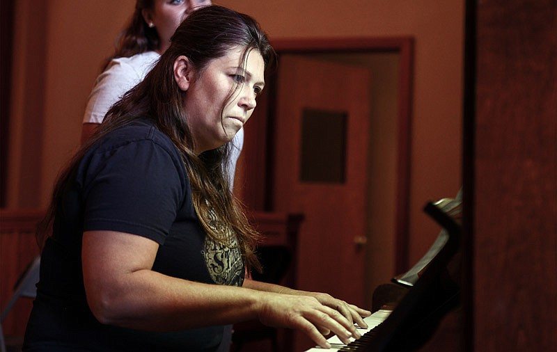 Rebecca Talbert sharply focuses her eyes on a scale sheet while playing the piano.