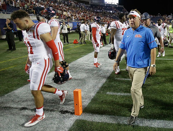 Mississippi head coach Hugh Freeze (right) leaves the field with players after losing to Florida State on Monday night in Orlando, Fla. 