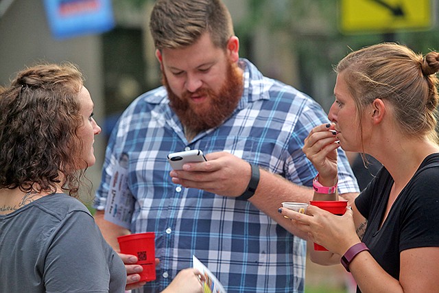 Jamie Faulconer, right, samples soup with Kyle Vaught, center, during Thursday Night Live's Soup Stock night in downtown Jefferson City. Participants could sample soups and vote on their favorite from restaurants including Spectators Bar, Bones In The Alley, Gumbo Bottoms Ale House, The Grand Cafe, Arris' Pizza, Ricks Cafe JC Mo, Madison's Cafe, YoYums, Capitol City CORK and Provisions.