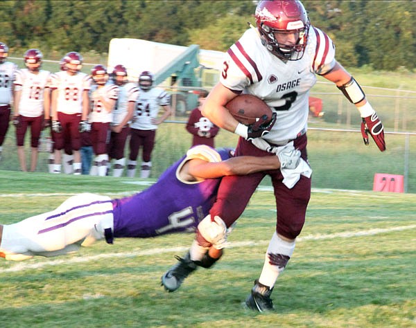 School of the Osage running back Dylan Riley attempts to pull away from Hallsville defender Jadon Kilpack during last Friday night's game at Hallsville.