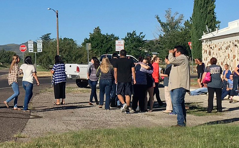In this photo provided by the Alpine Avalanche, people gather near the Alpine High School school campus after a shooting, in Alpine, Texas, Thursday, Sept. 8, 2016. A student died of an apparent self-inflicted gunshot wound, the Brewster County sheriff said. 