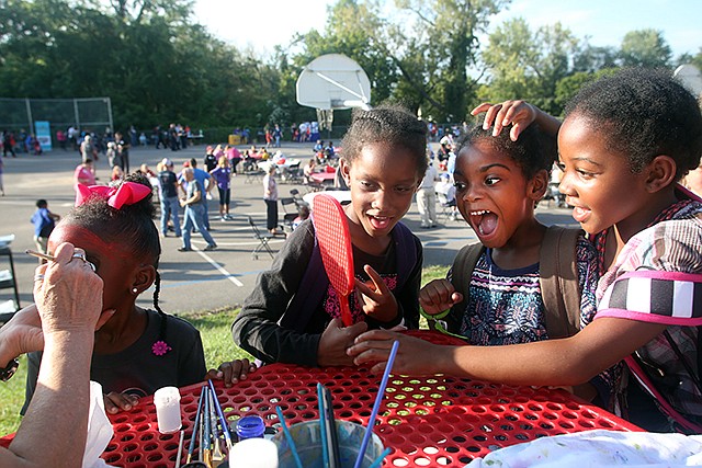 Damya Washington, 4, gets her face painted Friday, Sept. 9, 2016 while Ja-nille Hendricks, 7, Keryn Eckles, 5, and Charletha Adu, 7, make faces during an east-end community block party hosted by the First Christian Church at East Elementary School. 