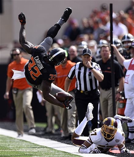 Central Michigan defensive back Sean Bunting, right, watches as Oklahoma State running back Chris Carson gets airborn after jumping over him during an NCAA college football game in Stillwater, Okla., Saturday, Sept. 20, 2016.