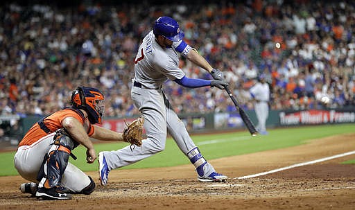 Chicago Cubs' Kris Bryant (17) hits a two-run home run as Houston Astros catcher Evan Gattis reaches for the pitch during the fifth inning of a baseball game Friday, Sept. 9, 2016, in Houston. 
