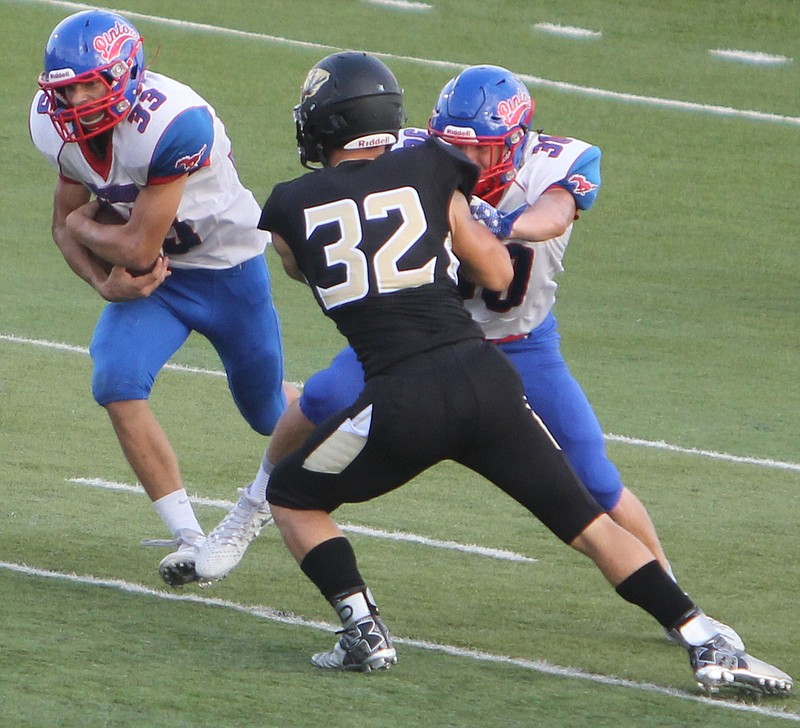 California running back Cory Friedmeyer darts through the hole while Jacob Adams sets the edge on Shane Randall of Versailles.