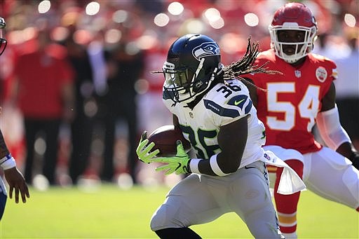 Seattle Seahawks running back Alex Collins (36) runs away from Kansas City Chiefs linebacker Dezman Moses (54) during the first half of an NFL preseason football game in Kansas City, Mo., Saturday, Aug. 13, 2016.