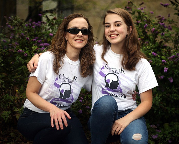 Mary Cremer, left, and her daughter, Lizzie Cremer, 17, pose for a portrait in front of Missouri River Regional Library in Jefferson City. Mary was diagnosed in 2014 with Chiari, a condition in which brain tissue extends down into the spinal canal. She said symptoms include intense headaches, tinnitus, dizziness, digestive problems, and eye problems, including sensitivity to light. She rarely takes off her sunglasses, even in overcast weather.