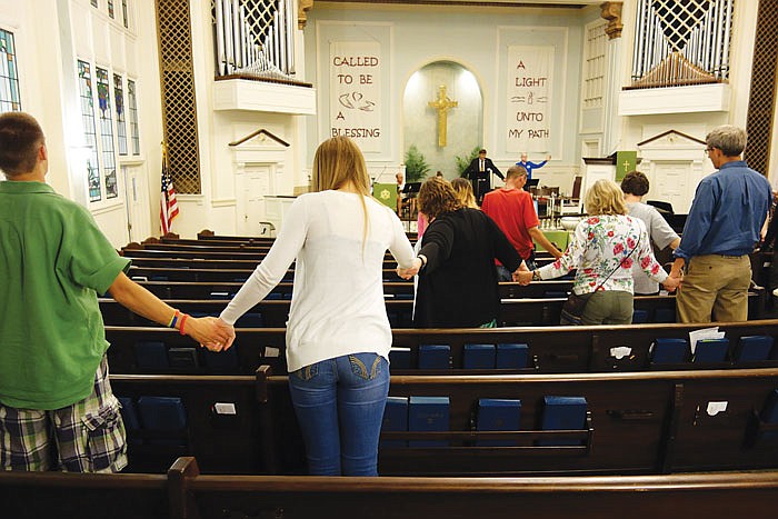 Attendees hold hands at the end of First Presbyterian Church's Sunday remembrance service marking the 15th anniversary of the terrorist attacks on Sept. 11, 2001.
