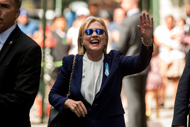 Democratic presidential candidate Hillary Clinton waves after leaving an apartment building Sunday, Sept. 11, 2016, in New York. Clinton's campaign said the Democratic presidential nominee left the 9/11 anniversary ceremony in New York early after feeling "overheated." 