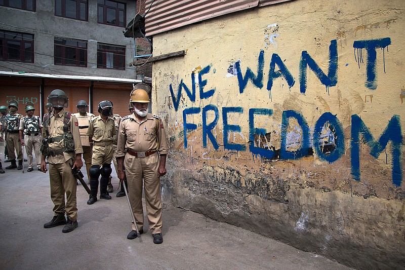 In this Aug. 12, 2016, file photo, Indian policemen stand guard during a curfew in Srinagar, Indian-controlled Kashmir. As Kashmir enters a third month of tense conflict marked by violent street clashes and almost daily protests following the July 8, 2016 killing of charismatic rebel leader Burhan Wani, Indian government troops backed by local police are maintaining a tight security lockdown throughout the region. That's left the local Kashmiri police, tasked with patrolling the streets, gathering intelligence and profiling anti-India activists, feeling demoralized, afraid and caught in the middle between the Indian authorities who employ them and the friends and neighbors who question their loyalties.