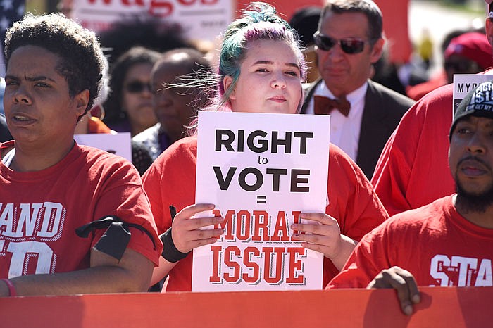 Madison Baker, 13, holds a sign during a minimum wage rally on Capitol Avenue on Monday. Baker is marching with Stand Up KC because her parents work in fast food and can't afford to pay their medical bills.