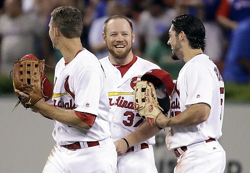 St. Louis Cardinals' Brandon Moss, center, celebrates with teammates Stephen Piscotty, left, and Randal Grichuk after defeating the Chicago Cubs 4-2 in a baseball game, Tuesday, Sept. 13, 2016, in St. Louis. 