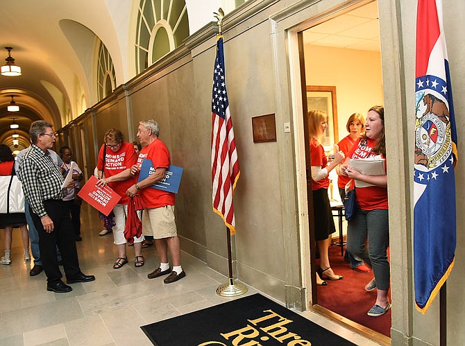 Jessica Coleman, right, leaves Sen. Doug Libla's office as she and members of the group Moms Demand Action for Gun Sense in America visit with individual legislators in their Capitol offices Wednesday. 