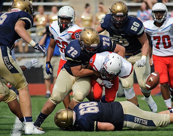 Helias defensive lineman Brede Stewart jars the ball loose from Kansas City Southeast running back Ramon Hatcher during a game this season at Adkins Stadium.