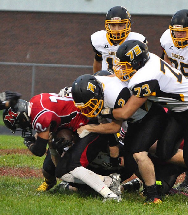 A group of Fulton defenders take Marshall sophomore running back Erik Mays to the ground during the Hornets' 26-14 win over the Owls on Friday night, Sept. 16, 2016 in Marshall.