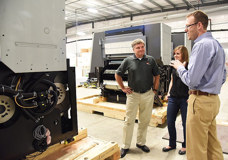 Jeff Davidson, right, tells Cassandra Atchison and Greg Meeker about his visit to the Heidelberg press manufacturing facility in Germany and about the precision with which the press gears were made. Davidson is vice president of corporate strategy for Modern Litho and Atchison is marketing director while Meeker serves as vice president of sales. The company is installing a new press that will increase its workflow capacity by 40 percent.