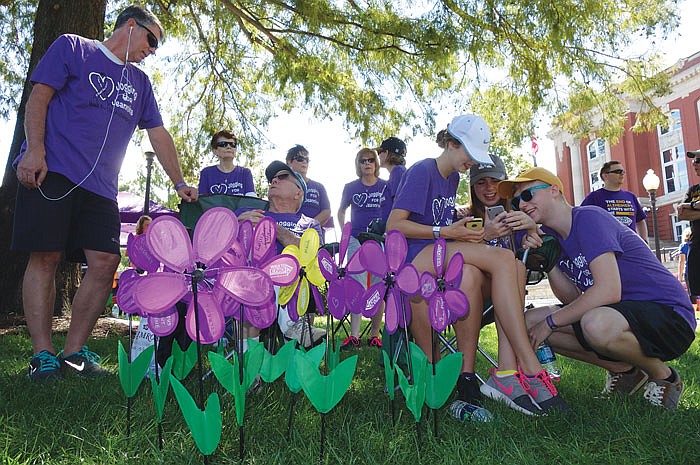 From left, Eddy Halter, Ralph Mayer, Malli Halter, Libby Hausman and Alex Hausman enjoy some time together in the shade before walking in Sunday's annual Walk to End Alzheimer's. Their 12-member team, Jogging for Jeannine, is named after Mayer's late wife, who suffered from Alzheimer's and died in May