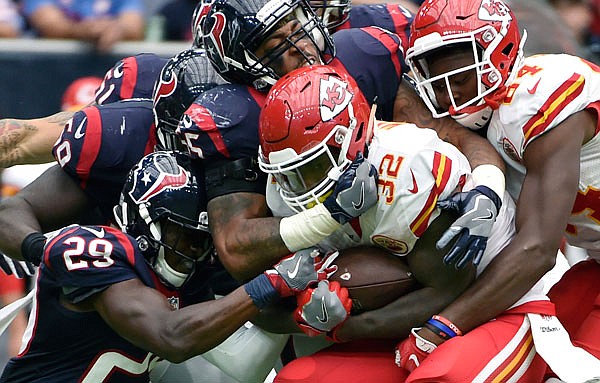 Chiefs running back Spencer Ware is wrapped up by Texans free safety Andre Hal (29) and linebacker Benardrick McKinney (55) during the second half of Sunday's game in Houston.