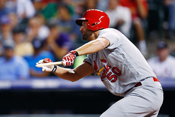 Adam Wainwright of the Cardinals follows the flight of his broken-bat single to drive in two runs in the fifth inning of Tuesday night's game in Denver.