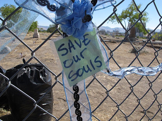 Ribbons and notes are tied to the fence around Hillside Cemetery Monday on the edge of downtown Reno, Nevada. Historic preservationists are outraged the owner of the cemetery has obtained a permit and posted a notice of plans to exhume hundreds of graves and transfer the remains to another section of the cemetery so the land can be sold for potential development. 