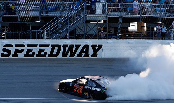 Martin Truex Jr. does a burnout after winning Sunday's NASCAR Sprint Cup Series race at Chicagoland Speedway in Joliet, Ill. Truex Jr. and Jimmie Johnson were not penalized after failing post-race inspection. 