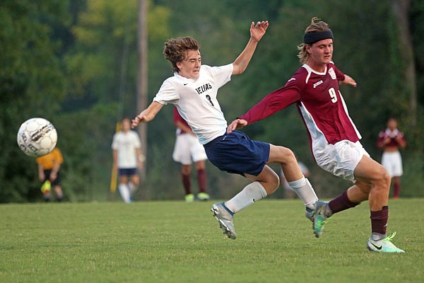 Logan Pfenenger of Helias slides into Stewart Meusch of Rolla during Wednesday's game at the 179 Soccer Park.