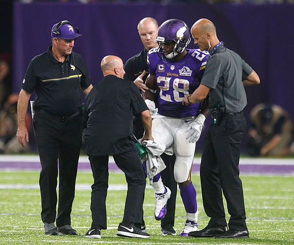 Vikings running back Adrian Peterson is helped off the field after getting injured during the second half of Sunday night's game against the Packers in Minneapolis. Peterson will undergo surgery on his right knee to repair a torn meniscus and Vikings coach Mike Zimmer said the star running back could return this season.