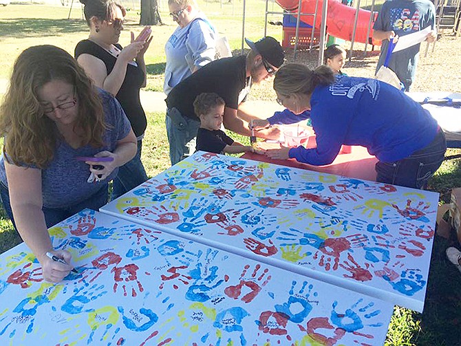 Participants in the 2015 Ashley Garrett Children's Art Festival collaborate on a banner. 