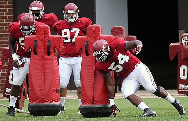 In this April 10, 2013, file photo, Alabama defensive lineman Dalvin Tomlinson participates in a drill during spring practice in Tuscaloosa, Ala. Tomlinson, a 6-foot-3, 310-pound defensive end, is a three-time Georgia state champion wrestler and former high school soccer player.