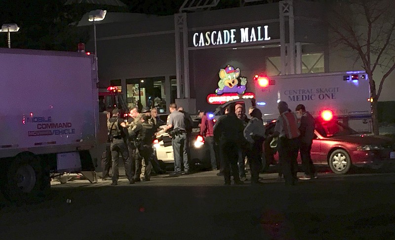 Law enforcement officers stand in front of the Macy's store at the Cascade Mall in Burlington, Wash., where several people were fatally shot, Friday, Sept. 23, 2016. Authorities in Washington State say several people have been killed during a shooting at the mall north of Seattle. At least one gunman is believed to be still at large. 