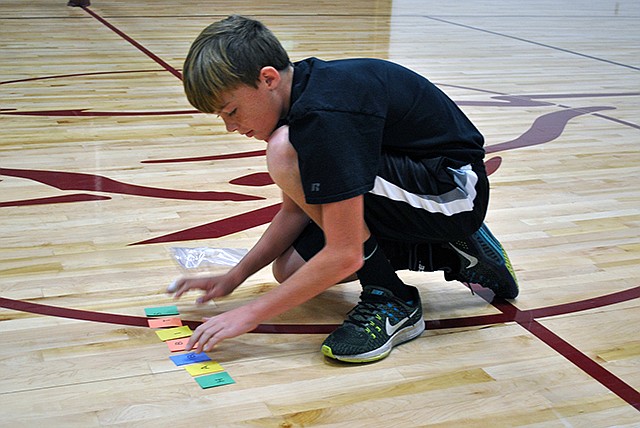 Eighth-grader Jaylan Bartels was the first to complete seven Scrabble physical activities and correctly spell the secret word during the fitness club's activity Friday at Eldon Middle School.