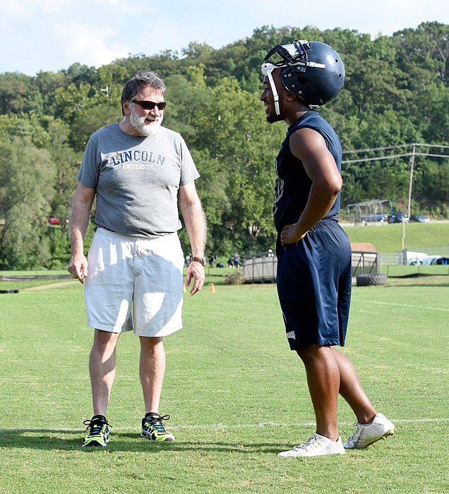 Pastor David Phelps talks to Lincoln University football player Amani Nelson, right, at a recent practice. Phelps is the team chaplain.