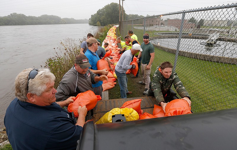 Volunteers and city workers place sandbags along the dike between the Cedar River and the water treatment plant in Cedar Falls, Iowa, Saturday, Sept.  24, 2016.   Authorities in several Iowa cities were mobilizing resources Friday to handle flooding from a rain-swollen river that has forced evacuations in several communities upstream, while a Wisconsin town was recovering from storms. 