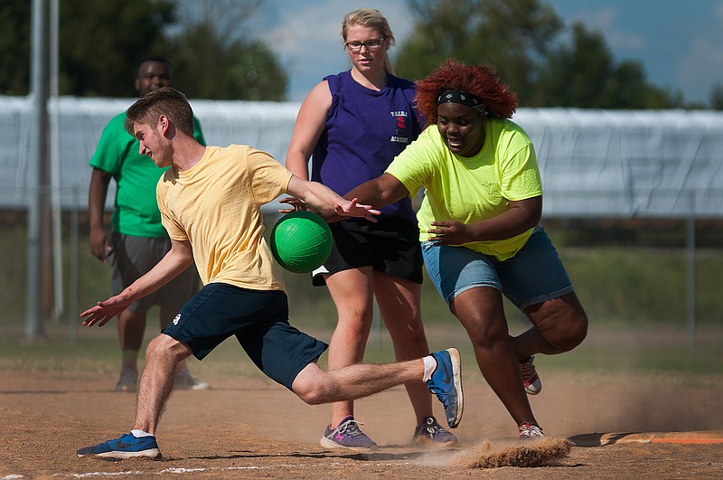 Texas High SC's Connor Brooks, left, tries to dodge being tagged out by Arkansas High Y2L's CeAira Burns on Saturday in the Kickball for a Cause fundraiser tournament at Hobo Jungle Park. The tournament, which benefited Shop With A Cop, was hosted by Pink Behind the Thin Blue Line, HealthCARE Express, and Texarkana, Ark., Police Department. Texarkana, Ark., Fire Department won the tournament, which raised $1,500. 