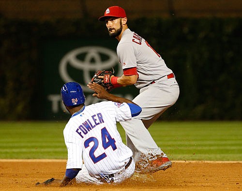 Cardinals second baseman Matt Carpenter looks to first after forcing out Dexter Fowler of the Cubs during Sunday night's game in Chicago.