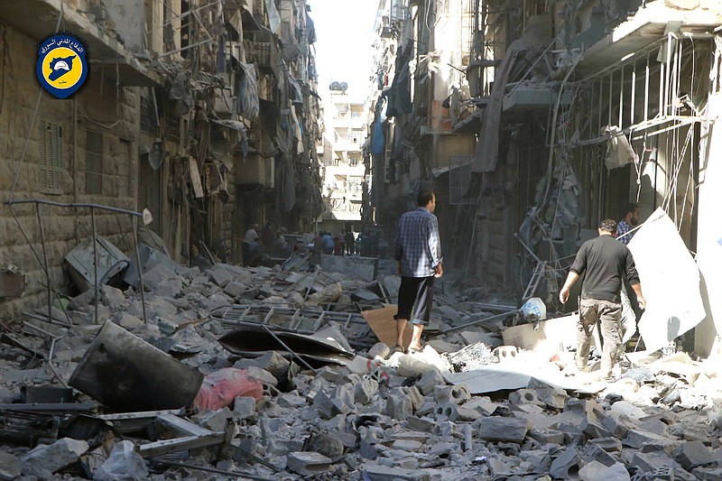 In this photo provided by the Syrian Civil Defense group known as the White Helmets, shows Syrian inspect damaged buildings after airstrikes hit in Aleppo, Syria, Saturday, Sept. 24, 2016. Syrian government forces captured a rebel-held area on the edge of Aleppo on Saturday, tightening their siege on opposition-held neighborhoods in the northern city as an ongoing wave of airstrikes destroyed more buildings. 