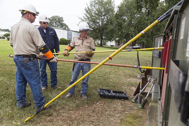 SWEPCO employees Darin Purifoy, Matt Rushing and Tom Littles test cable Monday at Texarkana College. Classes were canceled Monday after a transformer outage behind the welding shop caused the campus to lose power. 